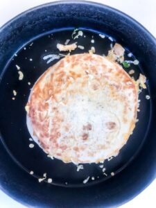 Cooked chicken quesadillas in a black pan on a white surface