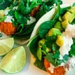 Buffalo cauliflower tacos with lime on a white plate