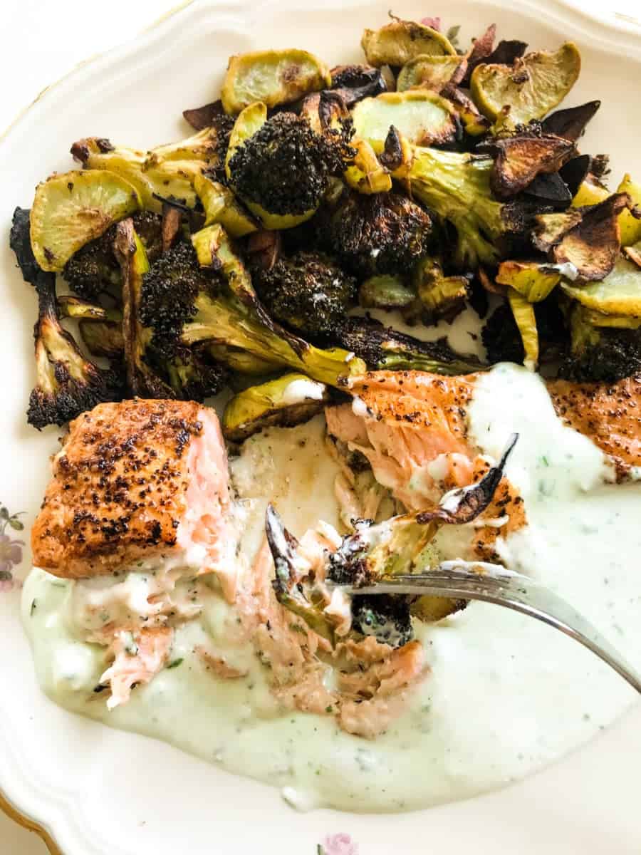 Lemon Pepper Salmon with Garlic Roasted Broccoli and Feta Yoghurt Sauce on a plate