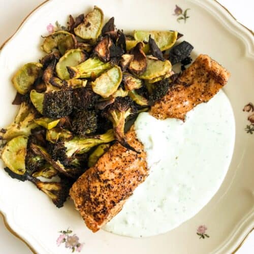 Lemon Pepper Salmon with Garlic Roasted Broccoli and Feta Yoghurt Sauce on a plate