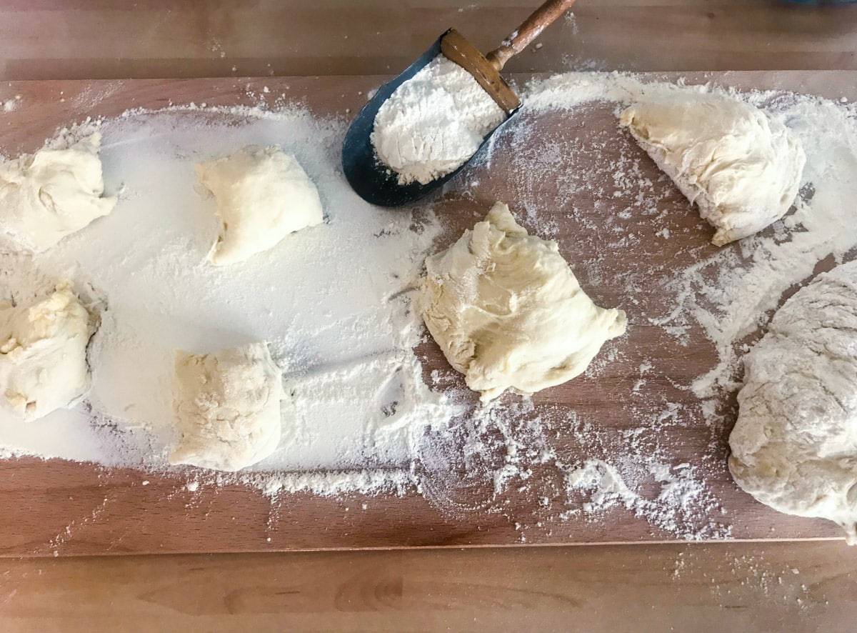 Overnight english muffins with flour on a wooden surface