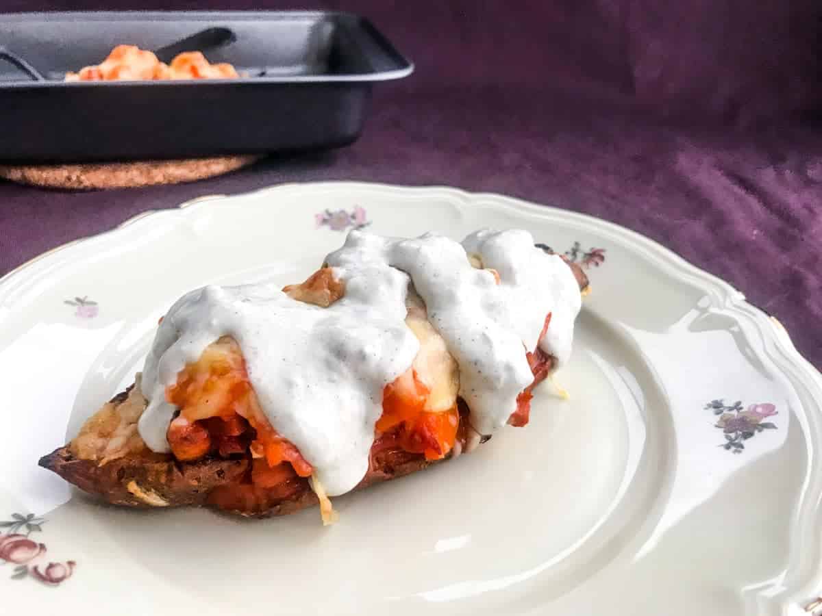 a sweet potato loaded with bufalo bacon and cheese topped with blue cheese sauce