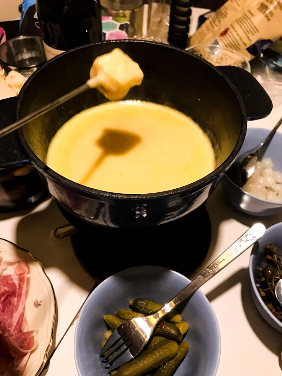 a pot of fondue with a piece of bread that has just been dipped in it