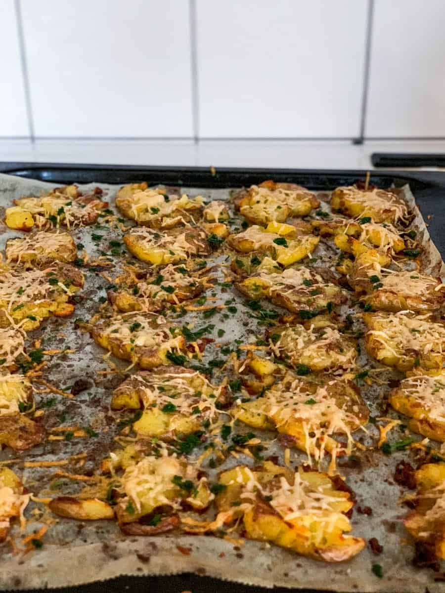 crispy garlic parmesan smashed potatoes on an oven tray