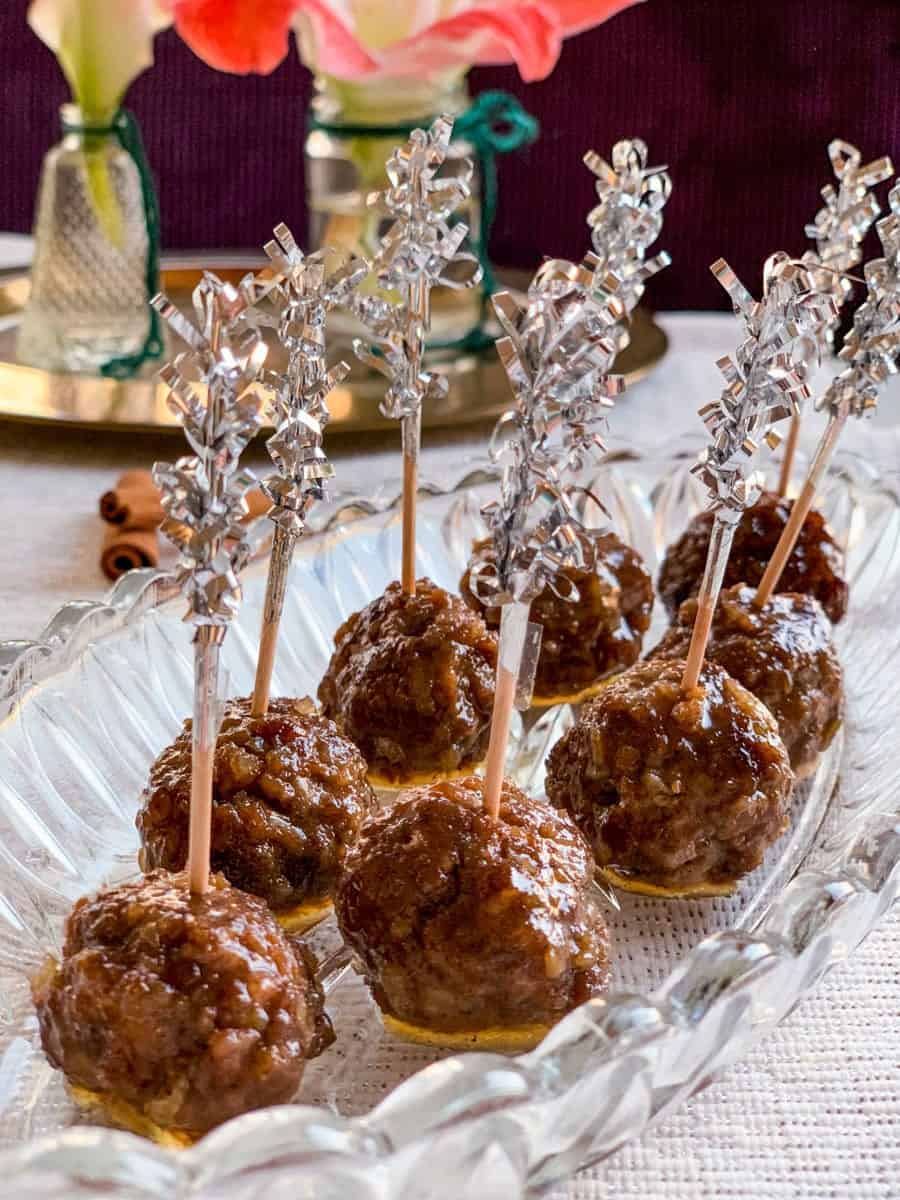 honey balsamic glazed gingerbread spice meatballs with tooth picks on a glass platter