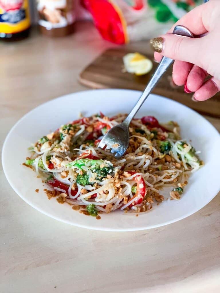 a fork in a plate of veggie pad thai