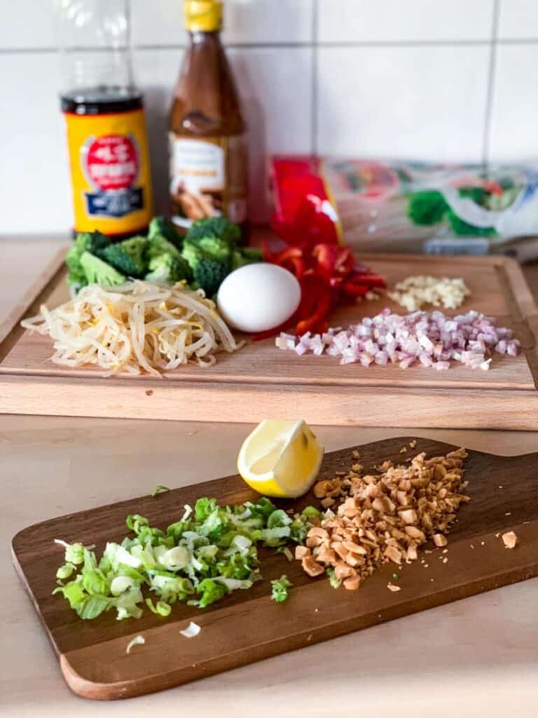 ingredients for veggie pad thai on two wodden choppign boards