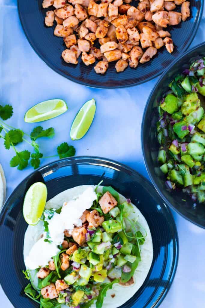 top view of a healthy salmon fish taco with ginger avocado salsa and topped with yoghurt