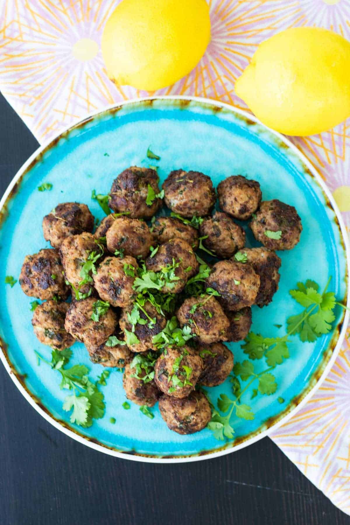 top view of lamb meatballs and two lemons