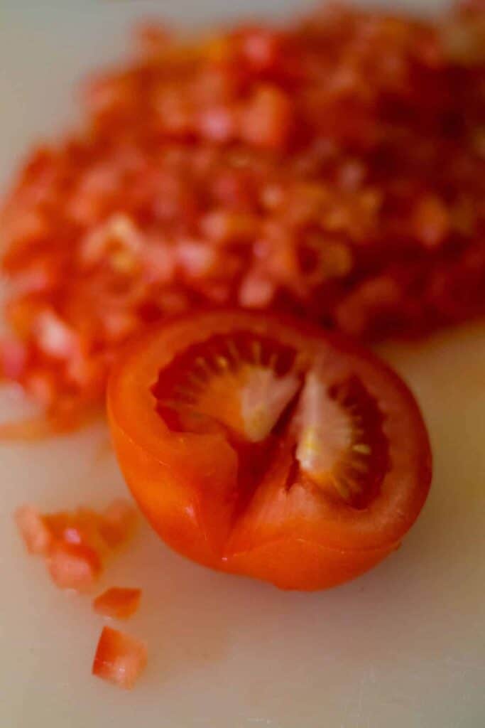 half of a tomto in front of chopped tomato