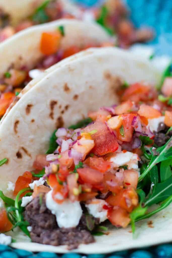 close-up of a vegetarian taco with black beans, feta cheese and pico de gallo