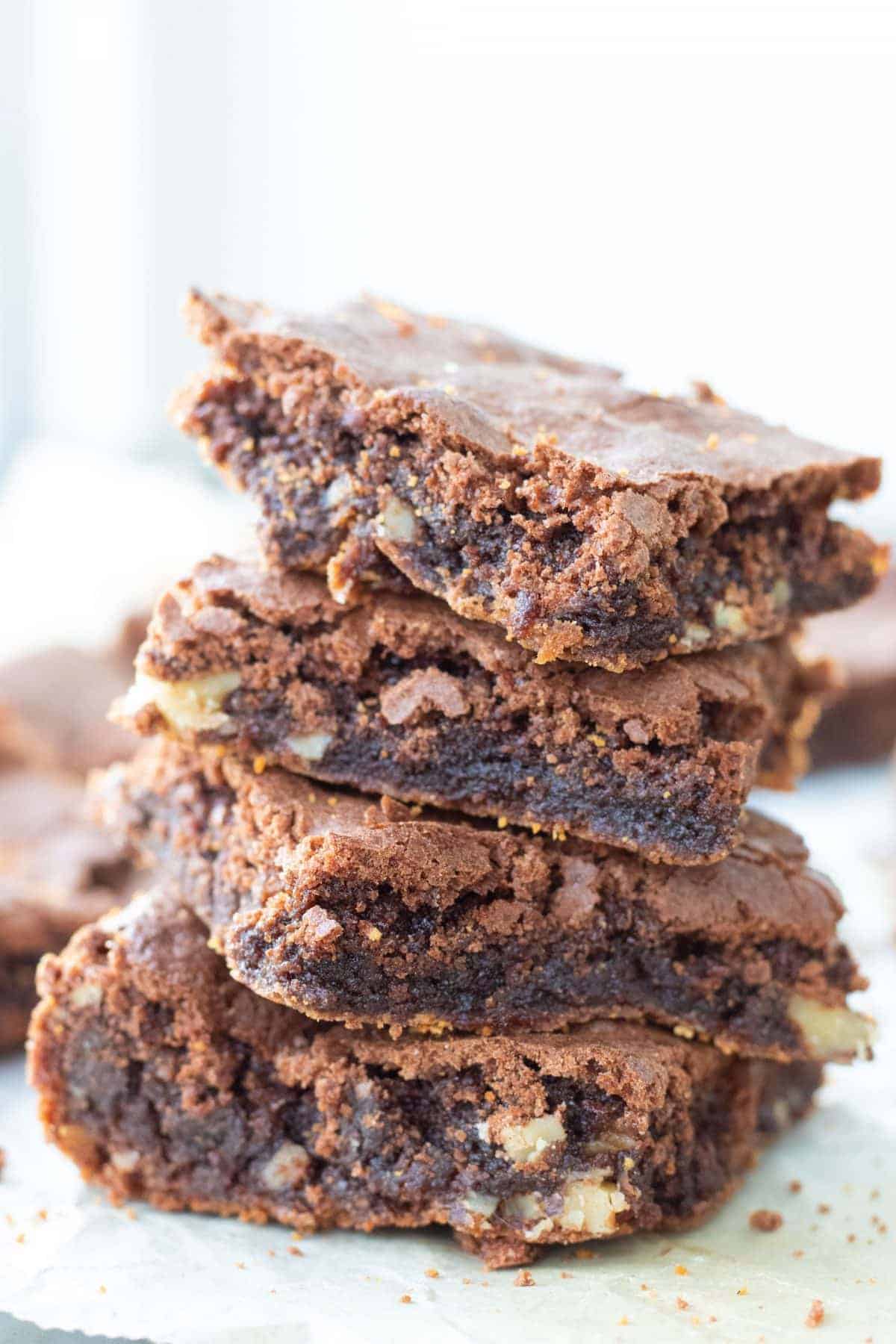 a stack of four brownies with cocoa powder.