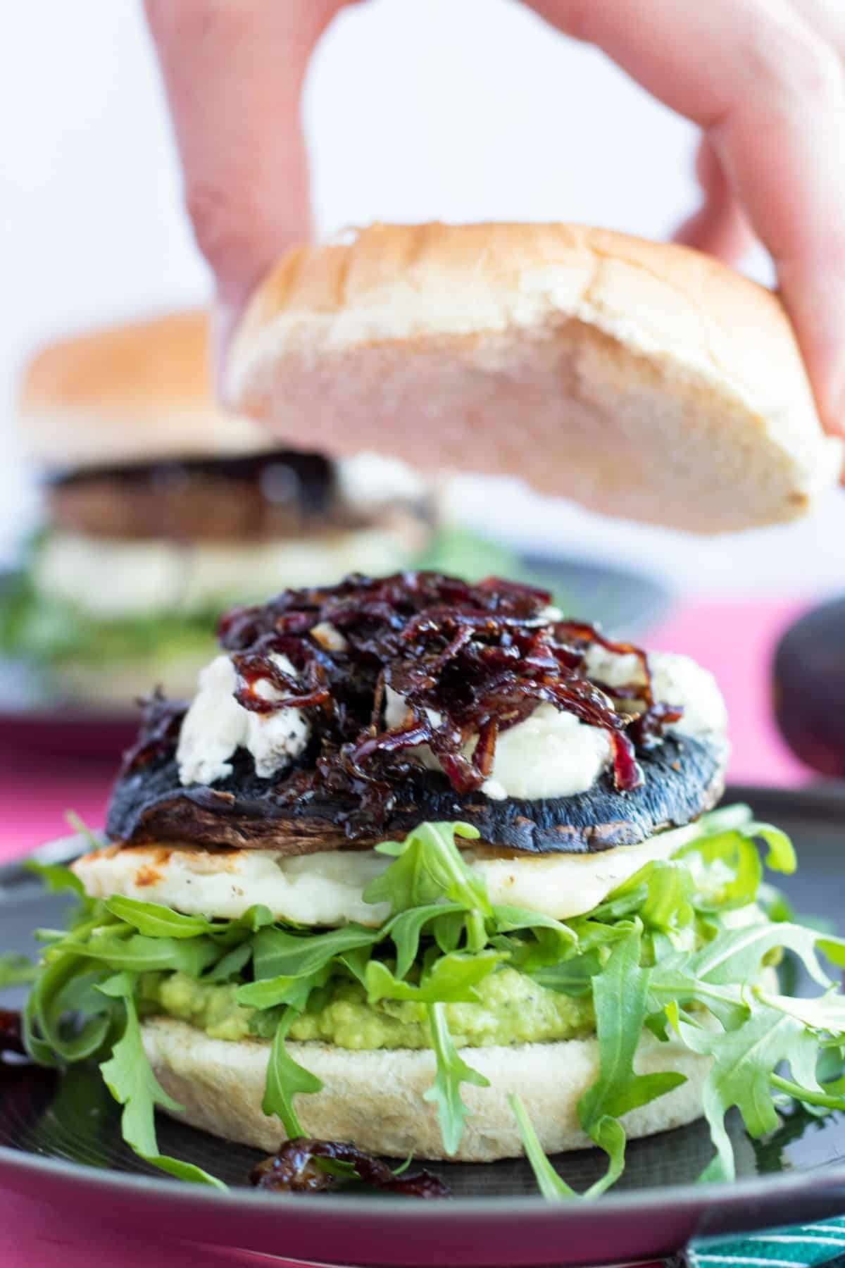 top bun being added to the portobello mushroom burger