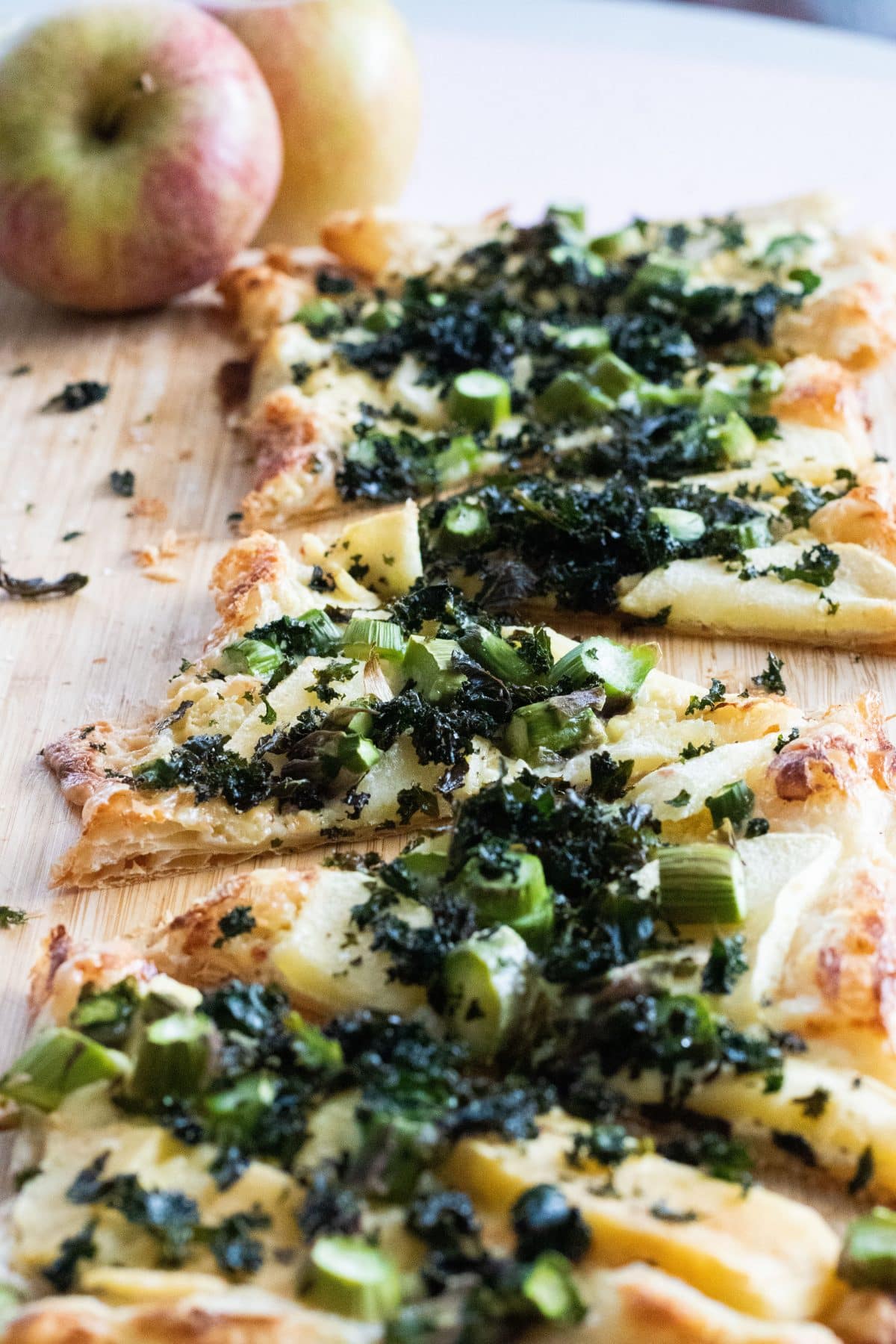 close-up of puff pastry pizza with blue cheese, apples and kale chips