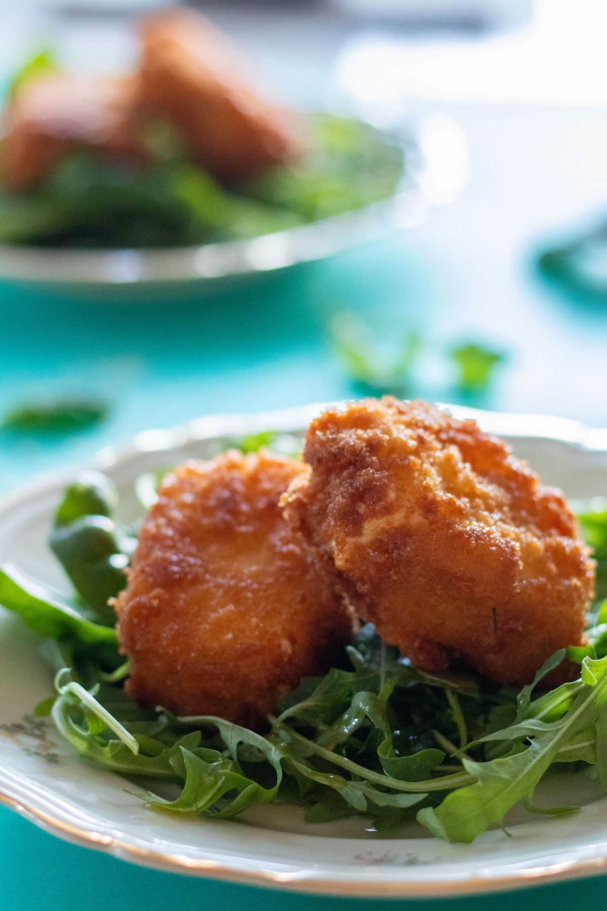 close-up of panko breaded feta cheese on a bed of greens