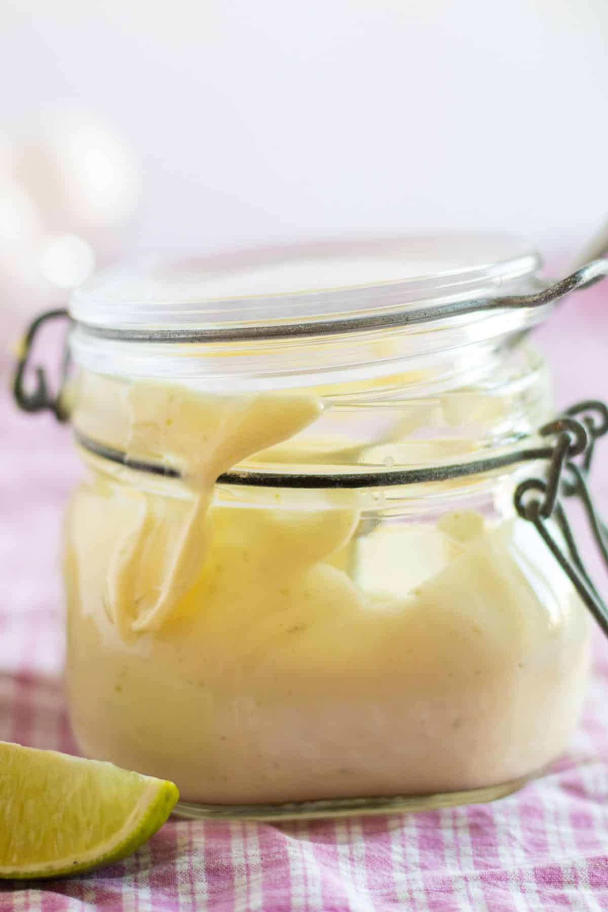 side view of a jar full of lime aioli