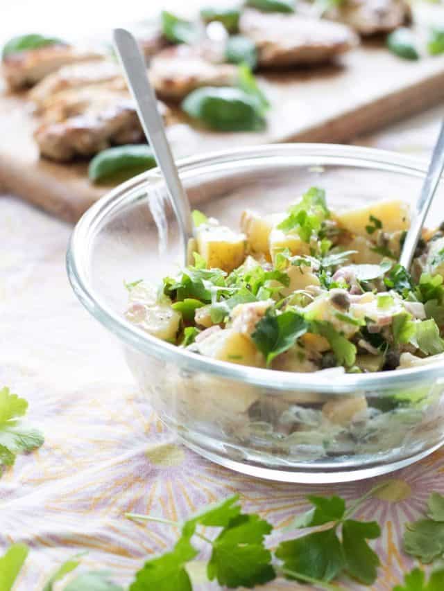 side view of french potato salad with parsley and capers