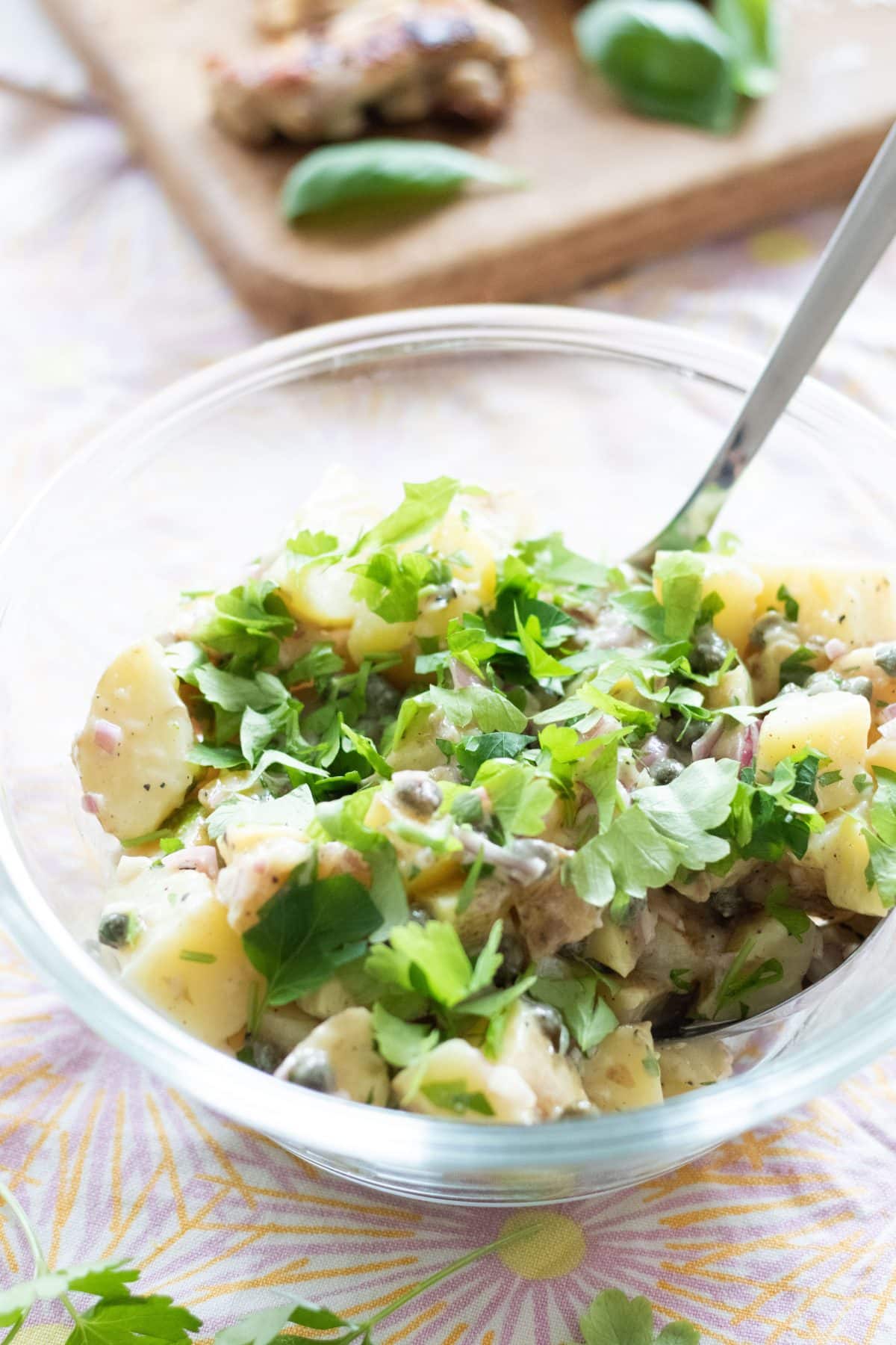 side view of french potato salad with parsley and capers