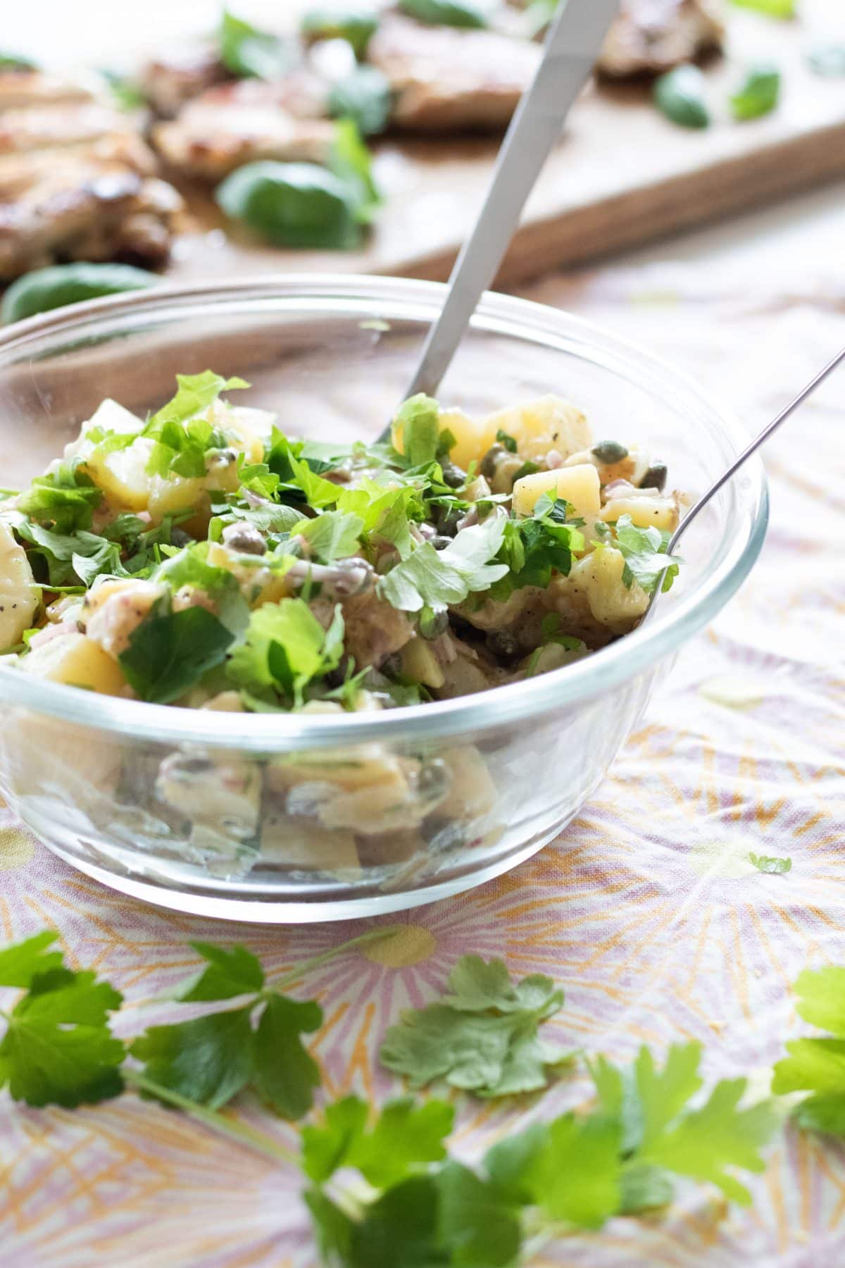 side view of french potato salad with parsley and capers