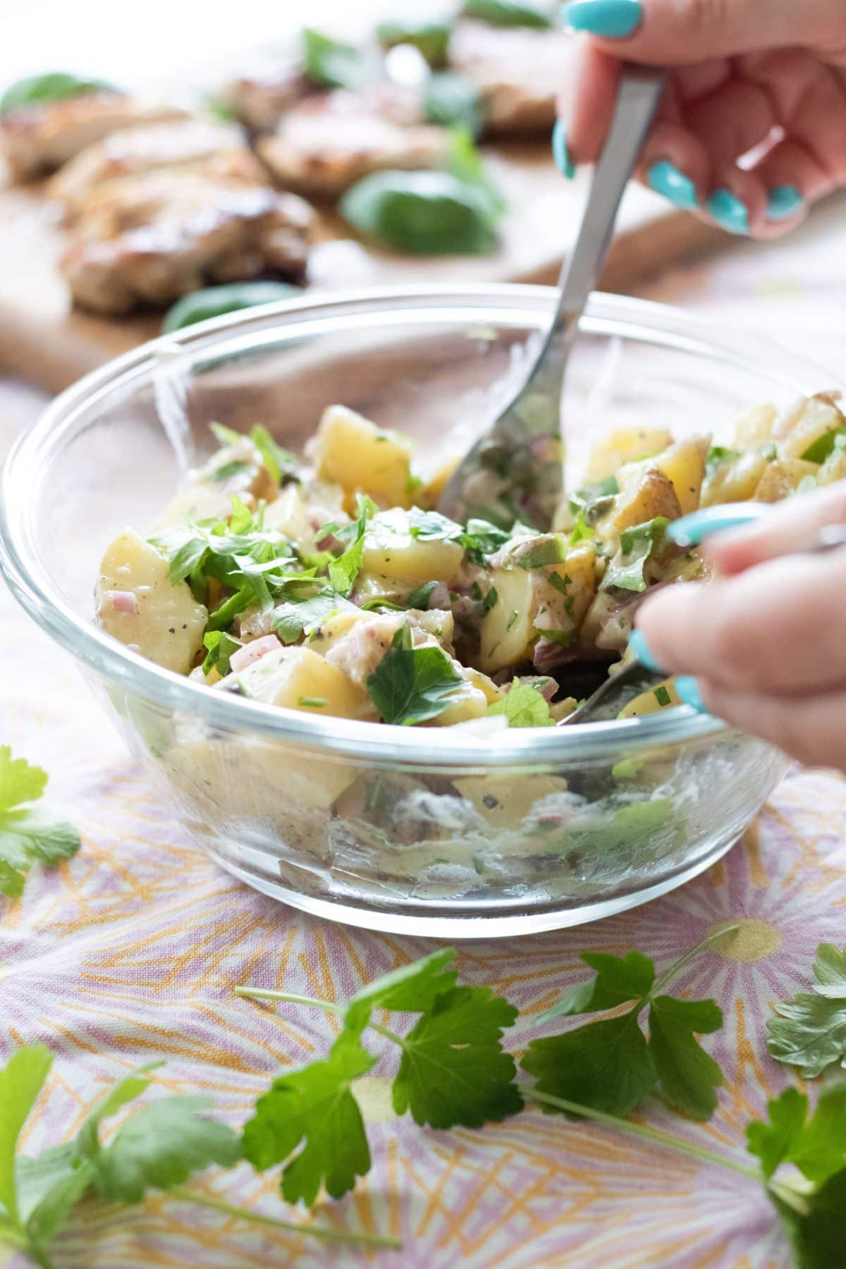 mixing together a potato salad with a knife and spoon