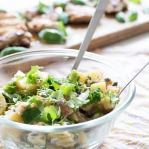 side view of french potato salad with parsley and capers