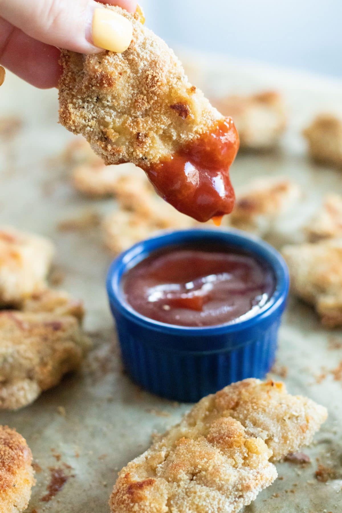 side view of a chicken tender that has been dipped into barbecue sauce