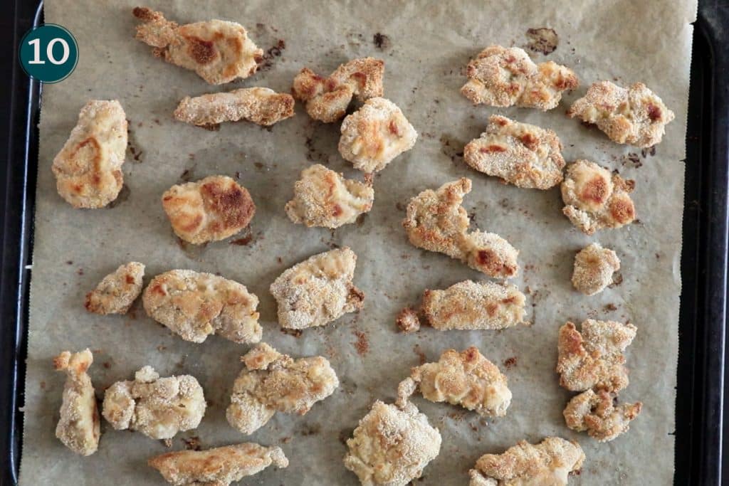 top down shot of breaded chicken tenders on an oven tray, after baking