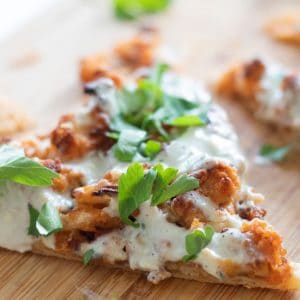 closeup of a slice of puff pastry pizza with buffalo cauliflower and blue cheese sauce