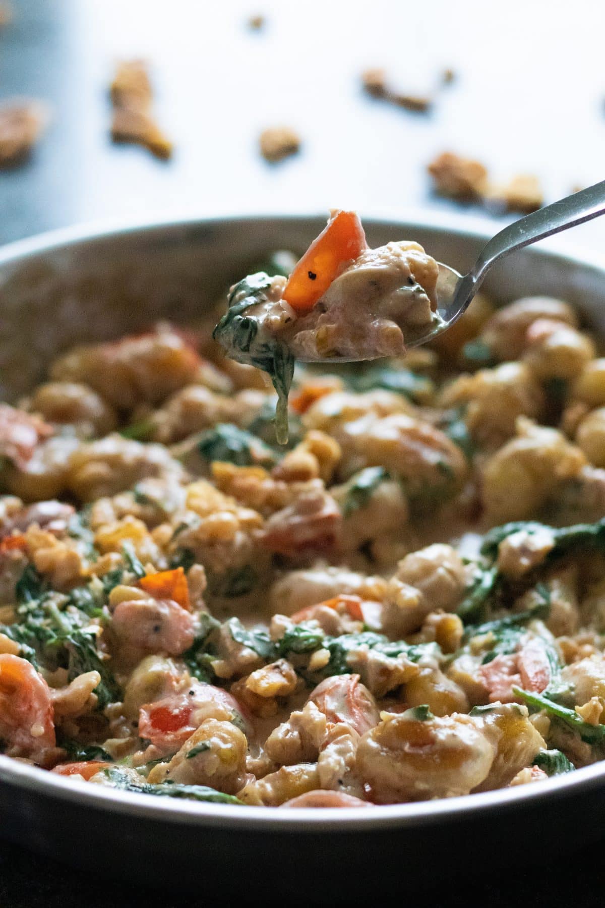 a spoonful of creamy gnocchi with gorgonzola picked up from a pan full of it.