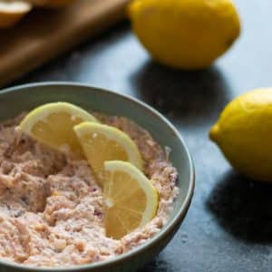 salmon pâté with hot smoked salmon in a bowl topped with lemon slices