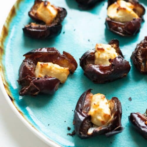 Feta stuffed dates served on a turquiose plate.