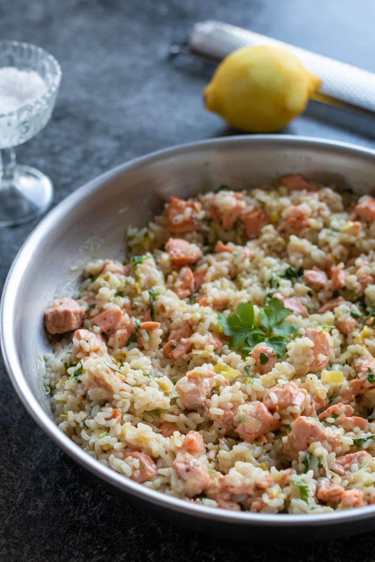 side view of salmon risotto with lemon.