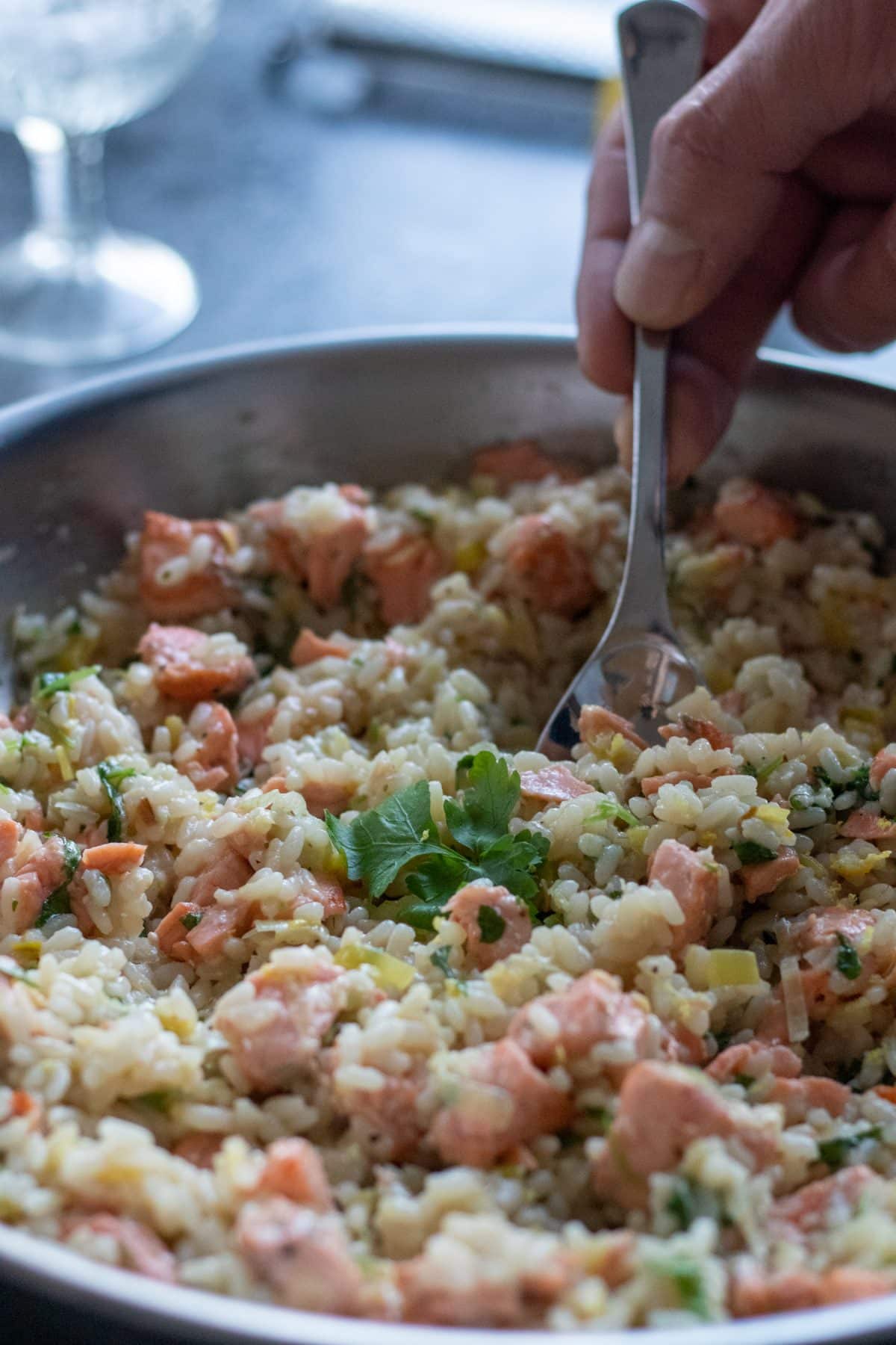 picking up a spoonful of salmon risotto