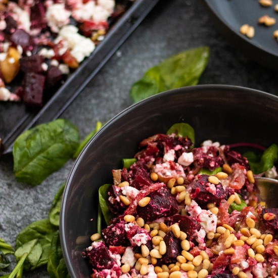 roast beetroot salad with feta cheese topped with pine nuts in a salad bowl