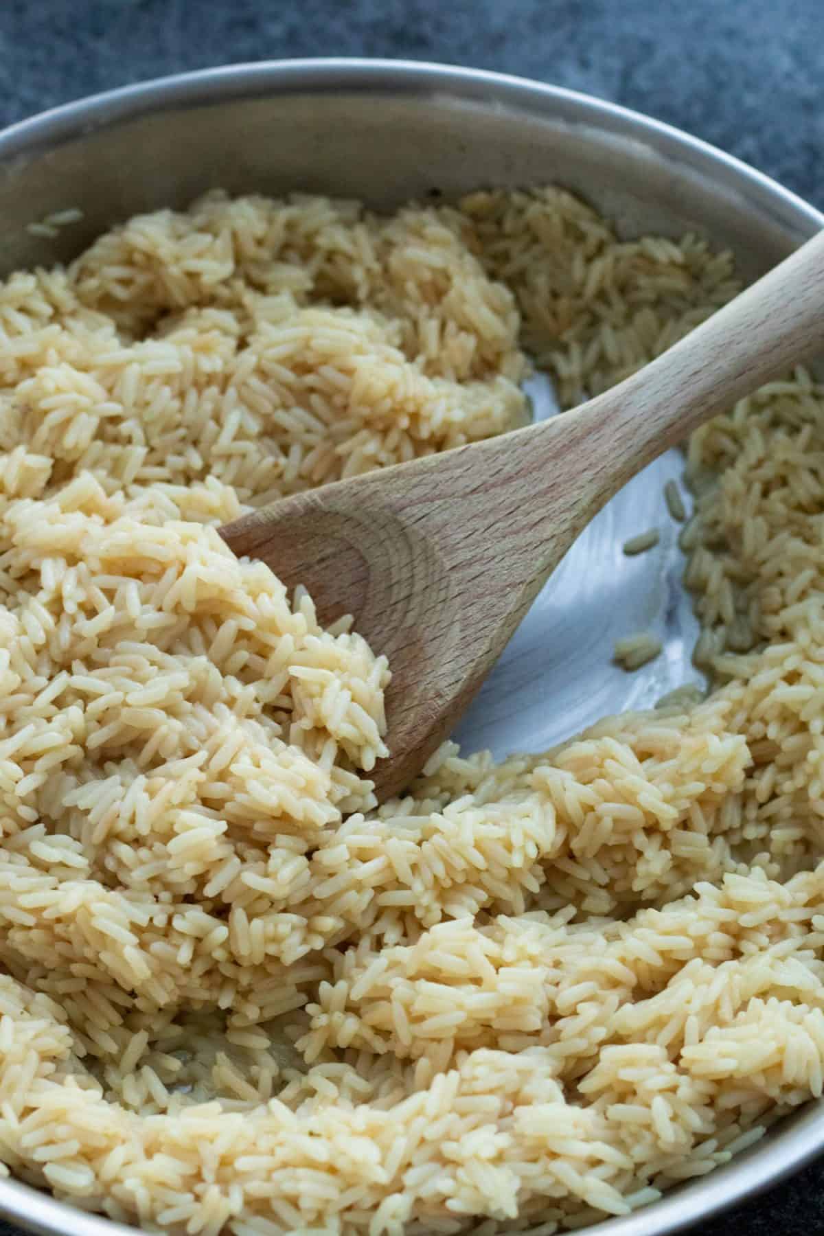 a frying pan full of rice with a wooden spoon