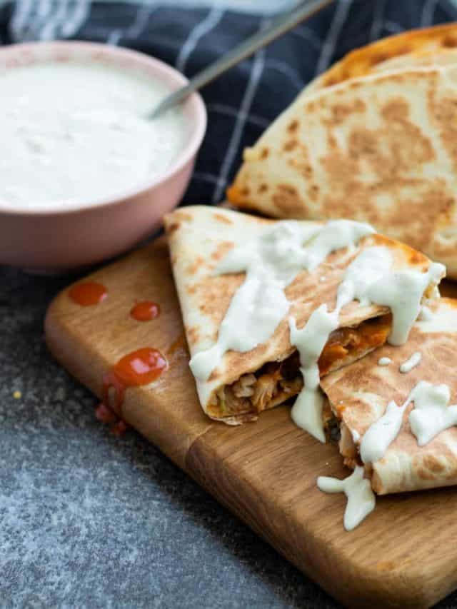 Buffalo chicken quesadillas topped with blue cheese sauce.