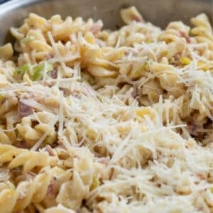 Crème fraîche carbonara in a pan topped with parmesan cheese.