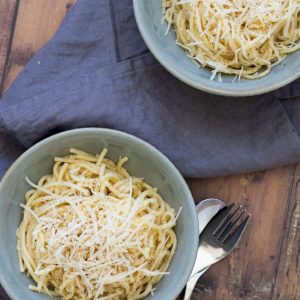 top down view of two bowls with garlic butter pasta on a wooden surface