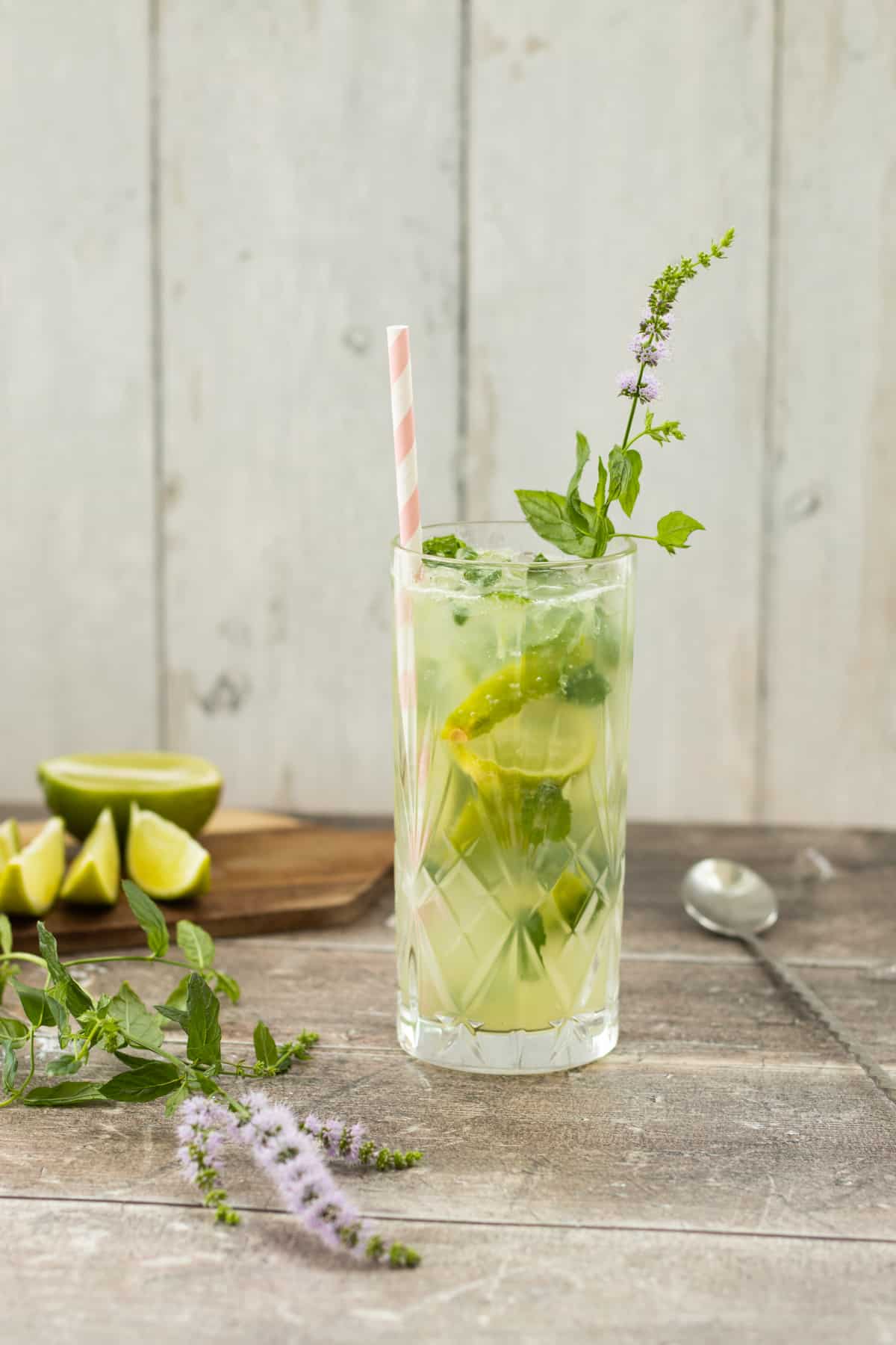 side view of a mojito mocktail with some lime in the background