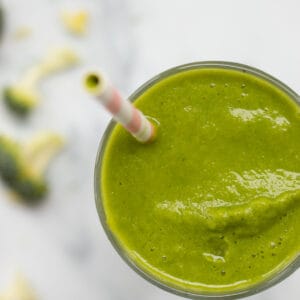 top down view of a green broccoli smoothie with broccoli next to it.