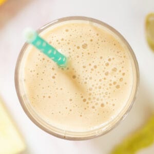 top down view of an apple banana smoothie decorated with a blue straw