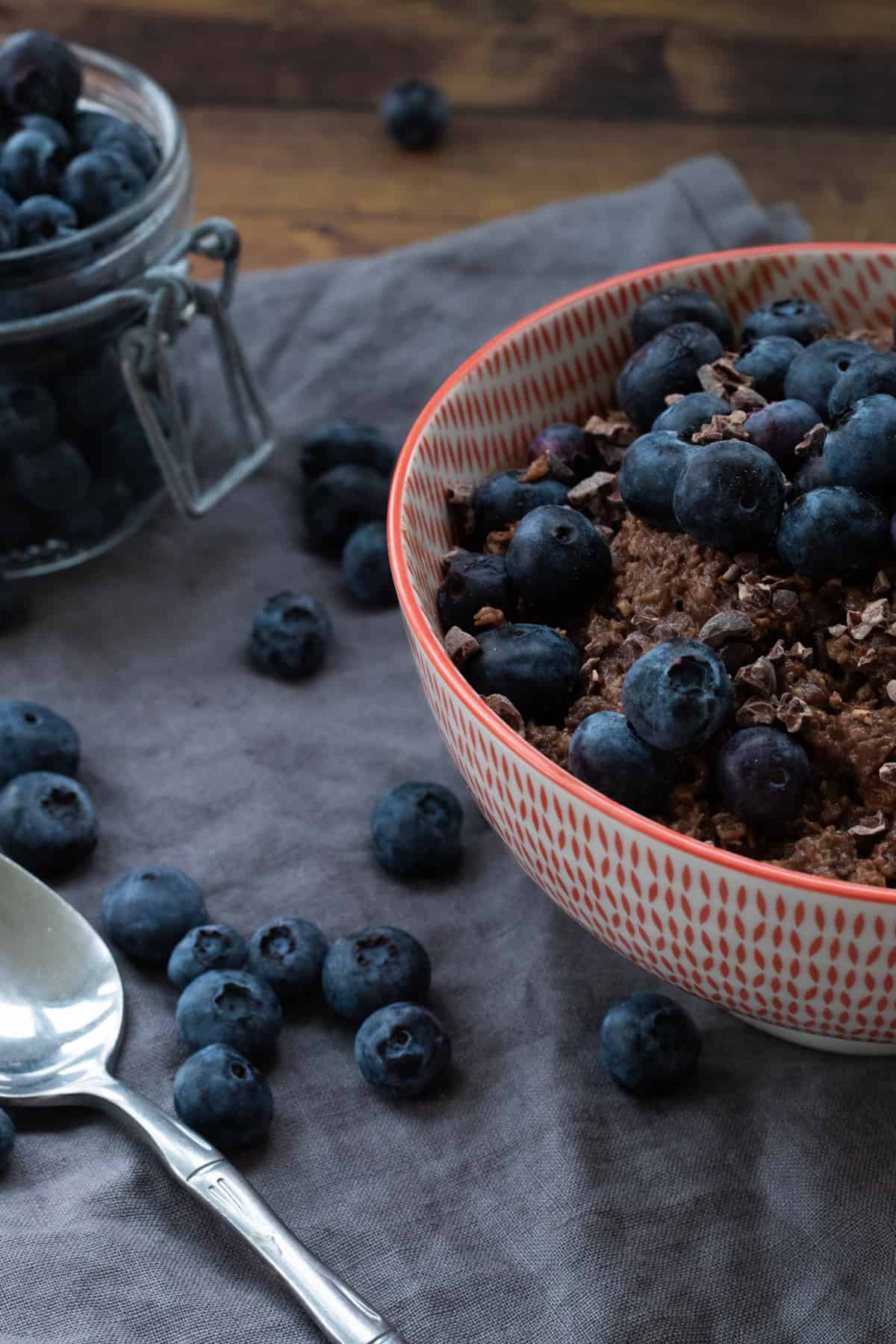 side view of a bowl of chocolate oatmeal topped with blueberries