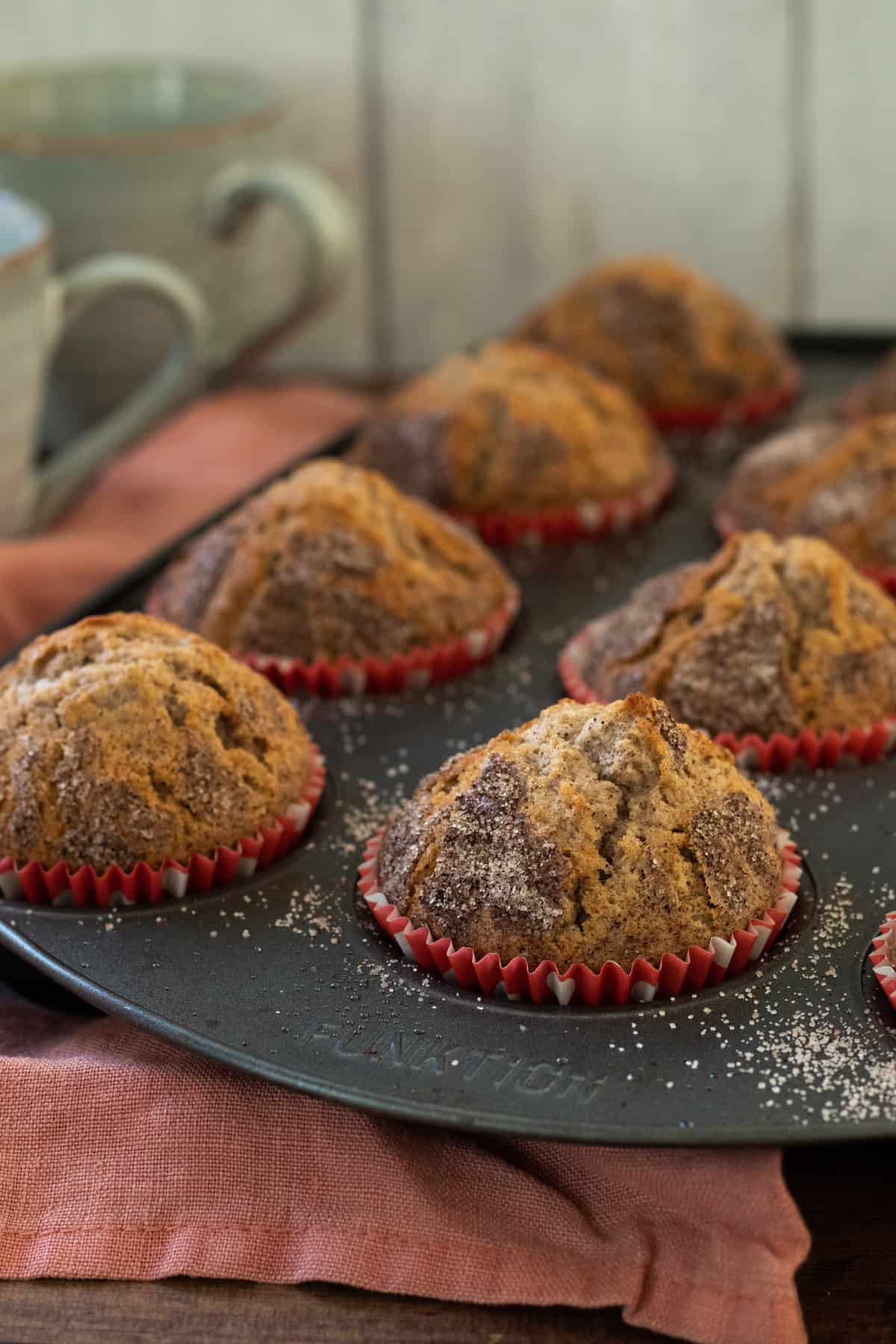 a tray full of cinnamon muffins.