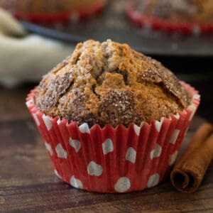 a cinnamon muffin cupcake in front of a tin full