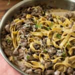 a pan ful of pasta with red wine pasta sauce with chicken and mushrooms