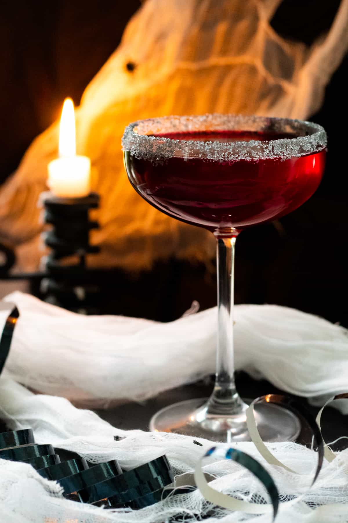 vampire margarita with a candle and cob webs in the background.
