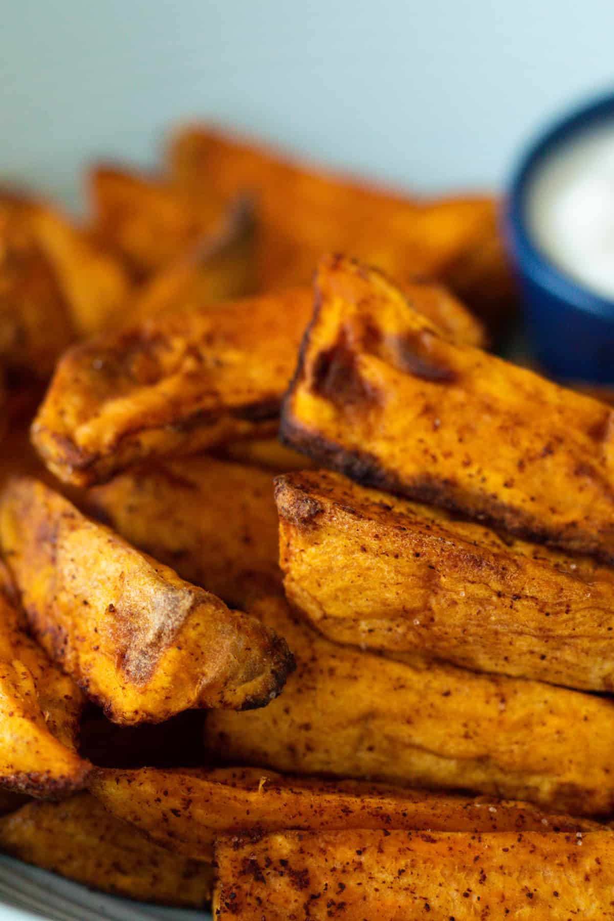 air fryer sweet potatoes on a plate with a white dip