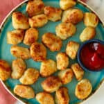 air fryer tater tots next to a small bowl with ketchup
