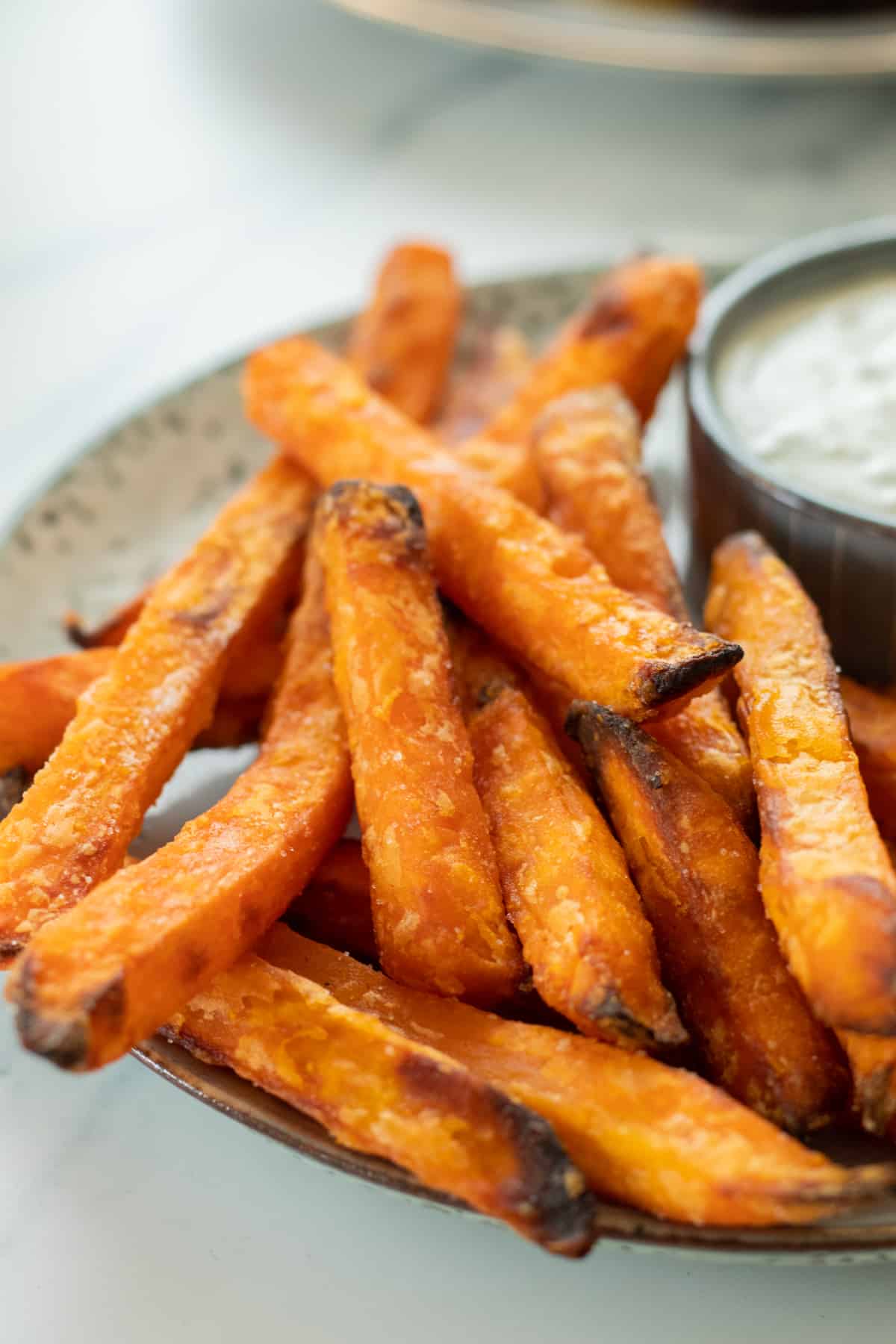 sweet potatoes on a plate next to a dipping sauce