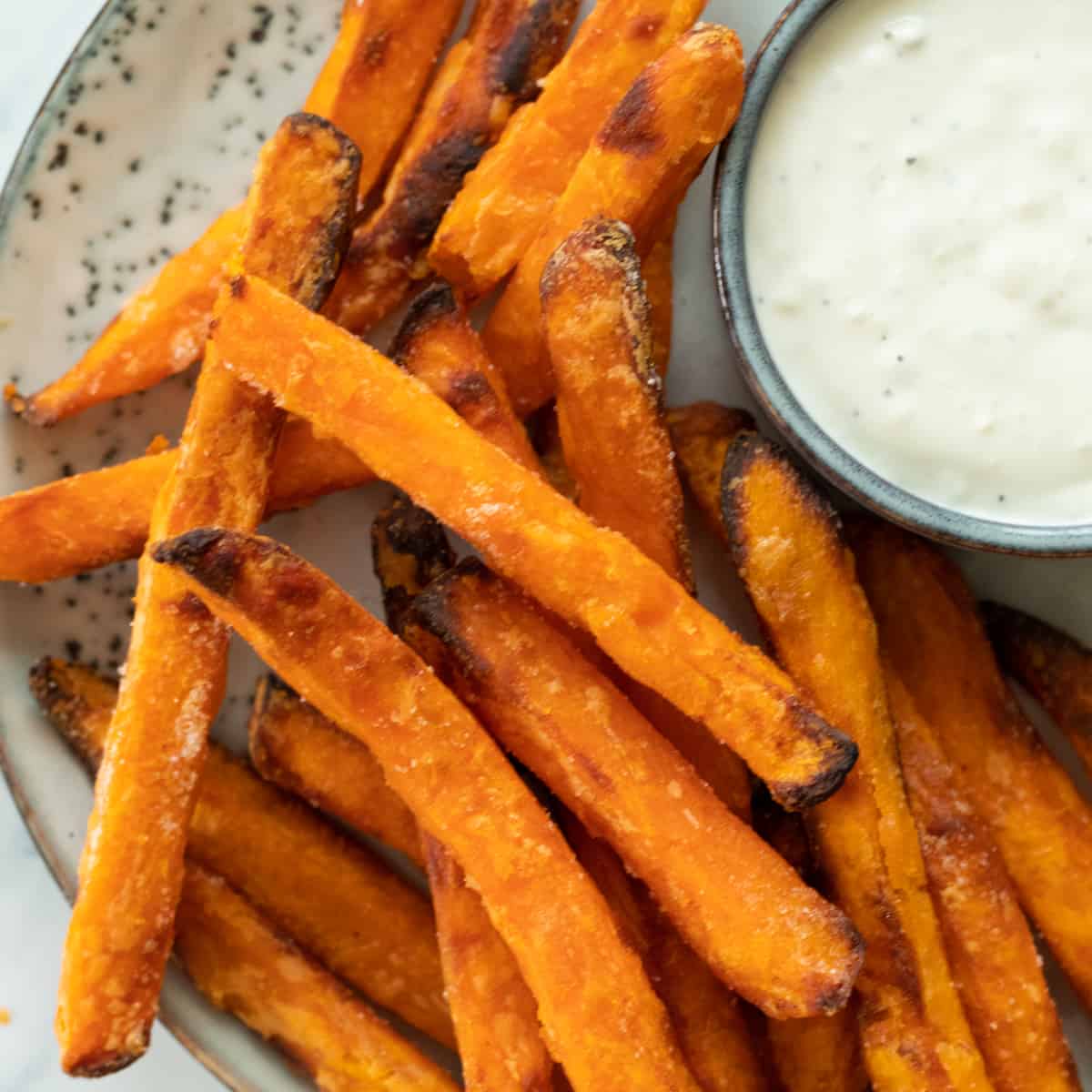 sweet potatoes on a plate next to a dipping sauce